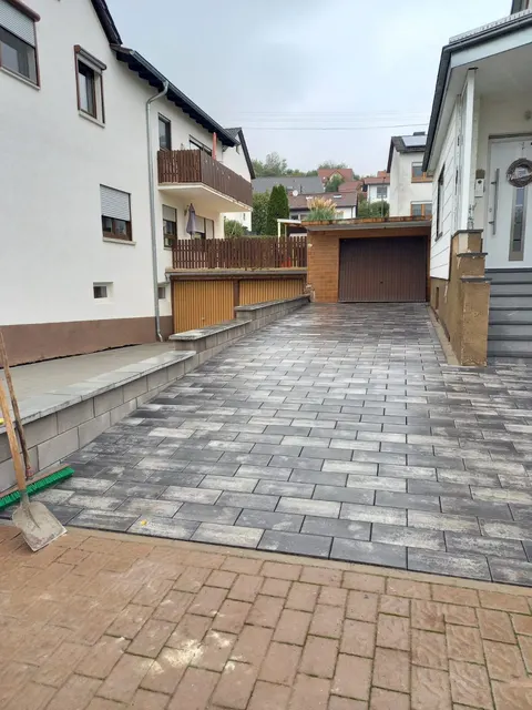 Einfahrt zur Garage am Hang in grau-weißem Mischpflaster, gebaut von C&H-Bau