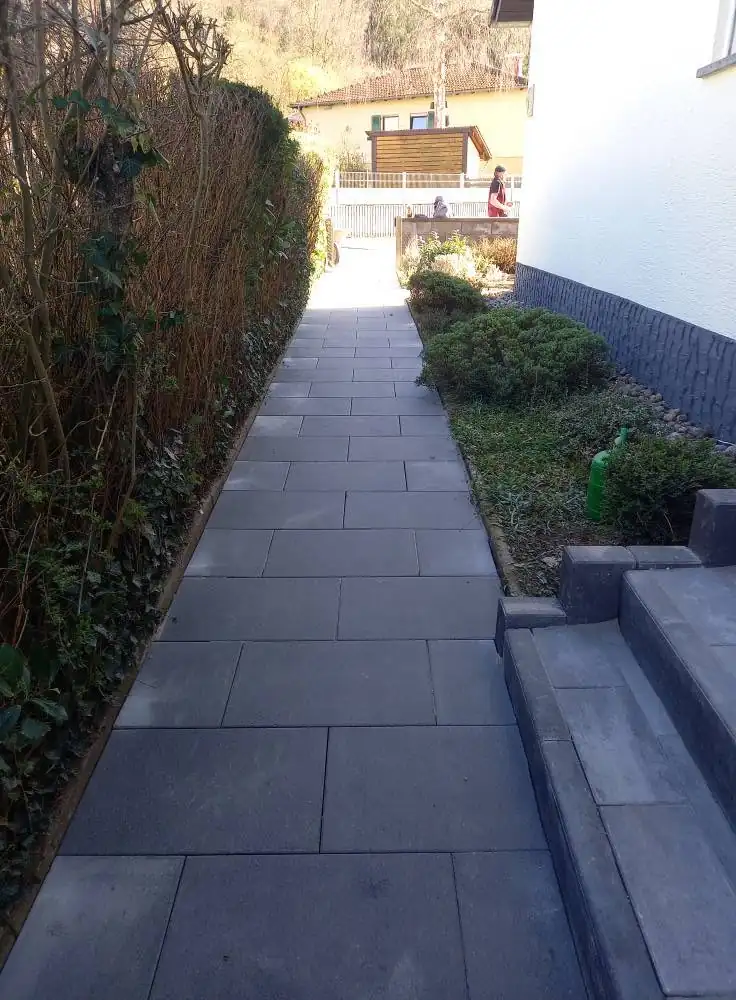 Plattenweg seitlich am Haus mit Stufen und Beet